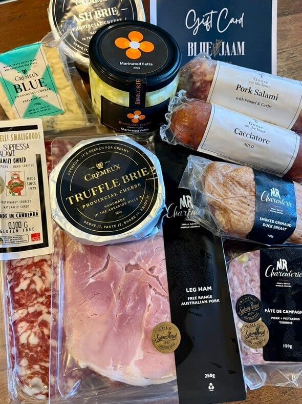 An array of deli meats and soft cheeses,