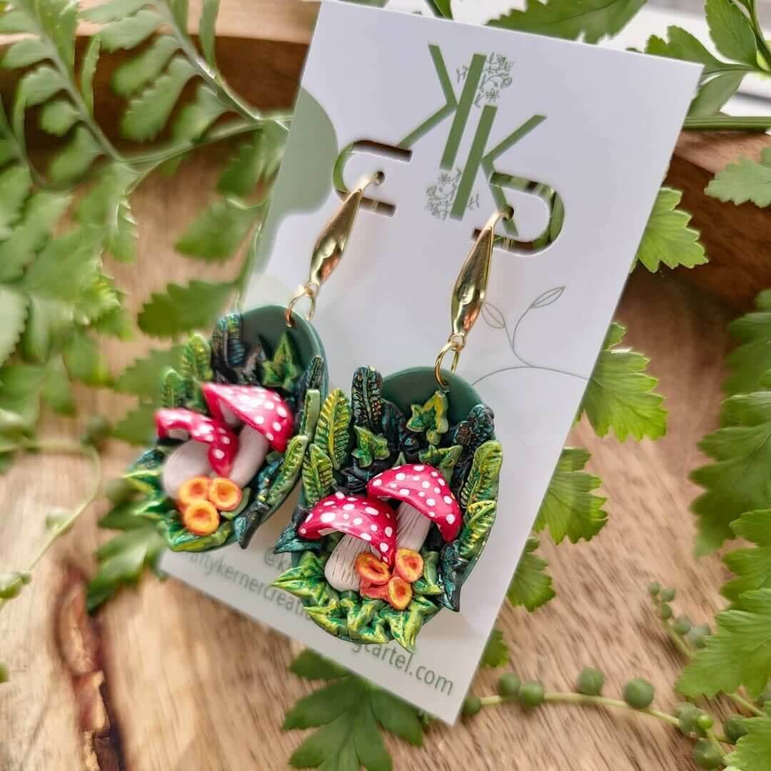 A set of woodland themed earrings featuring three bright red mushrooms