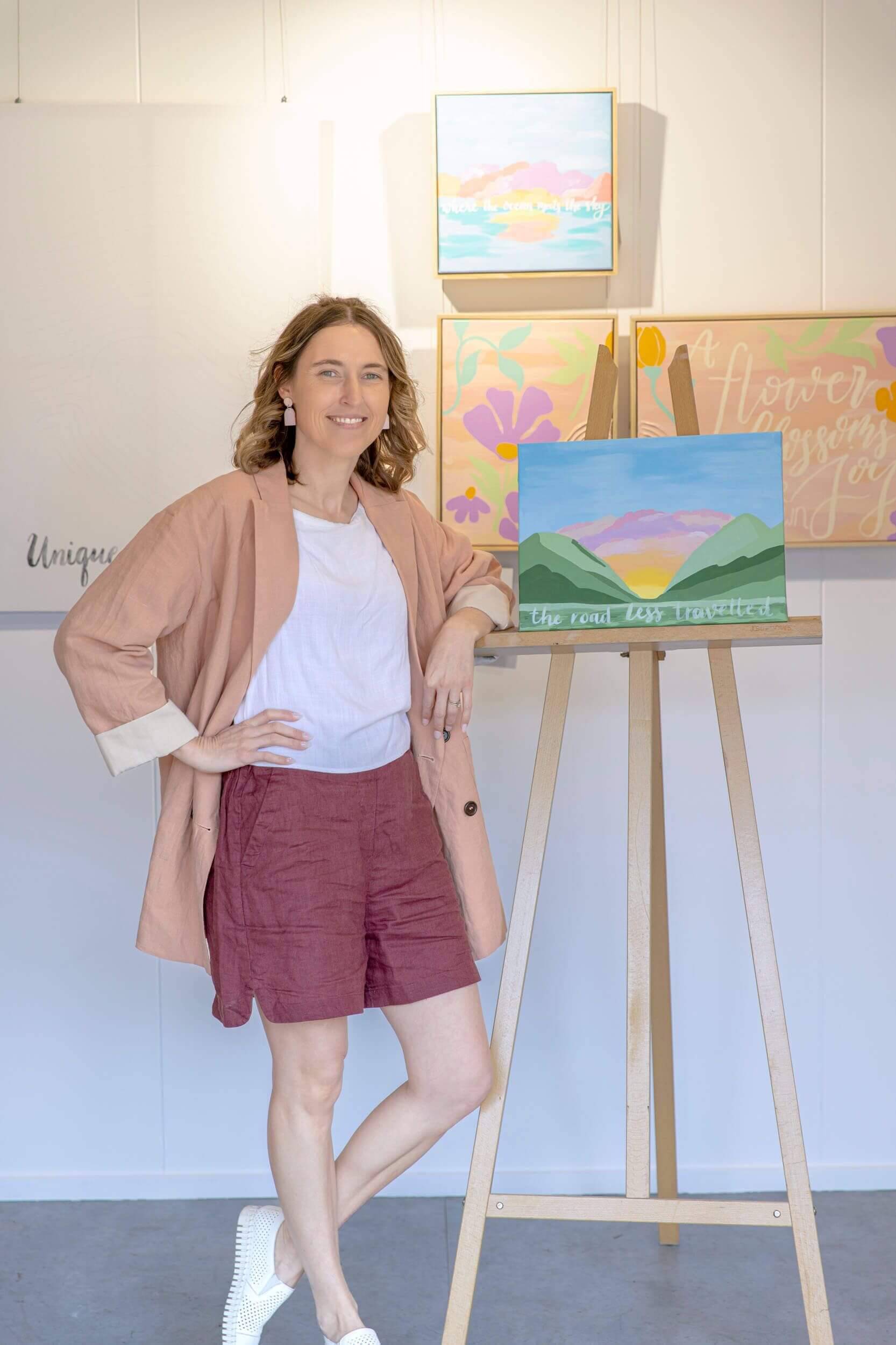 Susan Merchant, owner of Graphic Merchant, stands in front of an easel