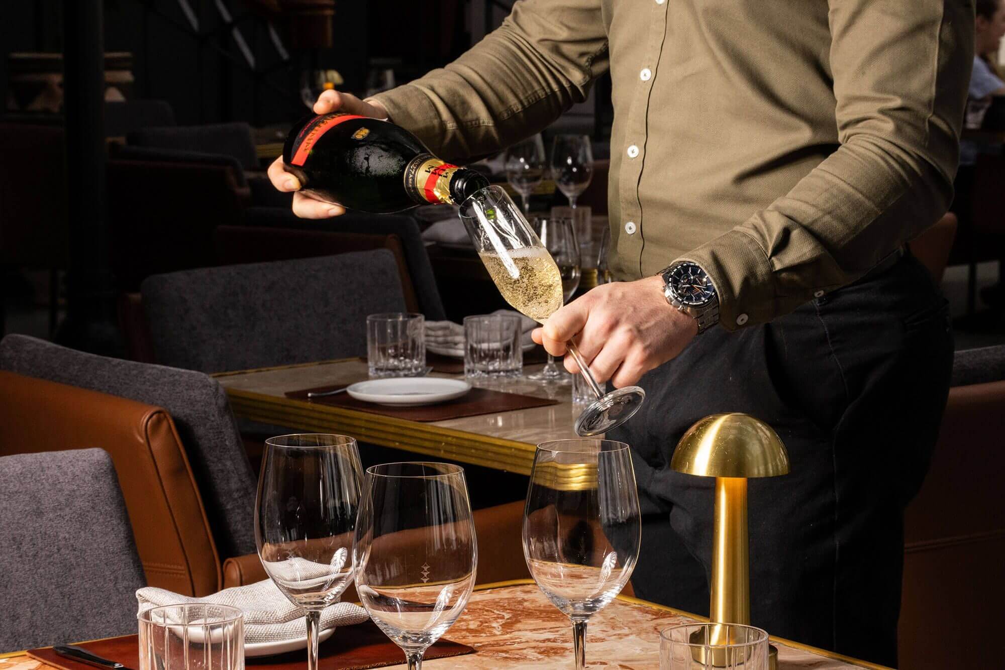 A man pouring champagne to guests.