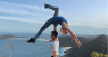 Duo AussieBela performing a dynamic acrobatic lift outdoors with blue sky background